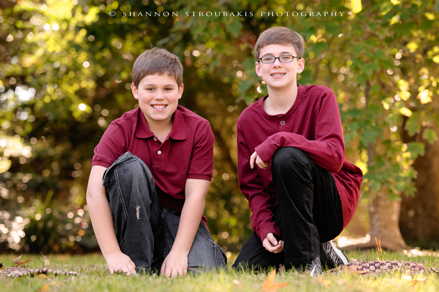 brothers posing for famiy portraits in the woodlands outdoors in the fall