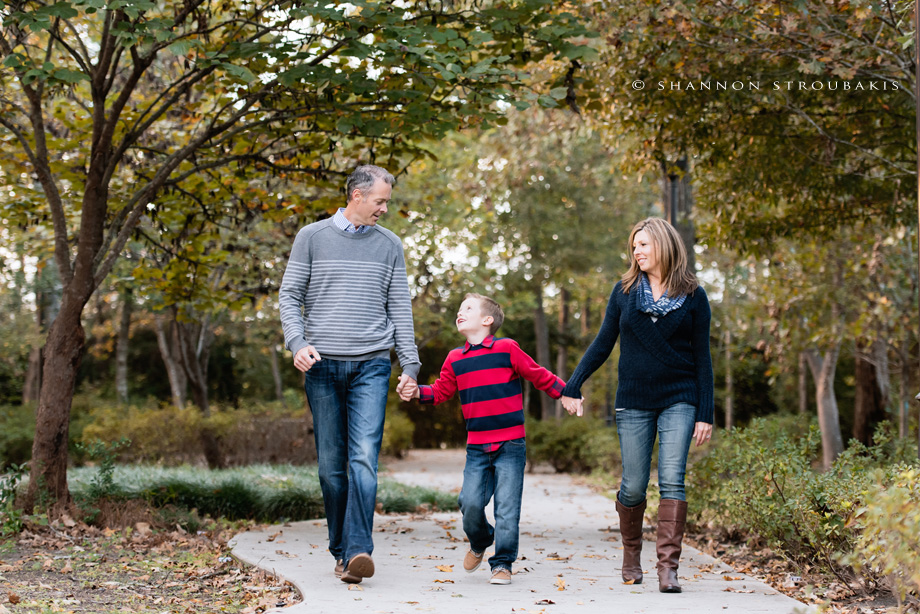 lifestyle portrait of a family in the woodlands walking in the park